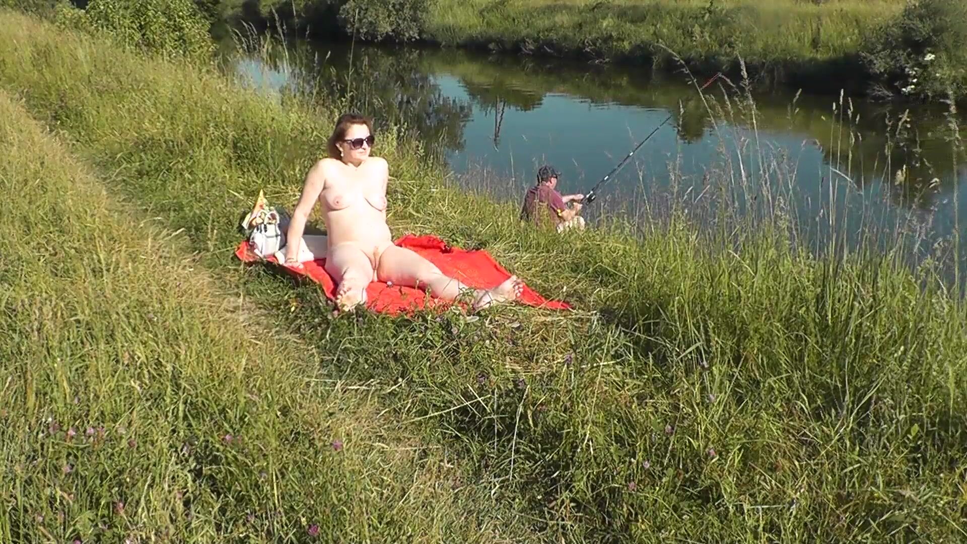 MILF sexy Frina am Flussufer entkleidet und sonnt sich nackt. Zufällige Mann Fischer beobachten für sie, und am Ende beschlossen, nackte Frau zu verbinden. Wilder Strand. Nudisten Strand